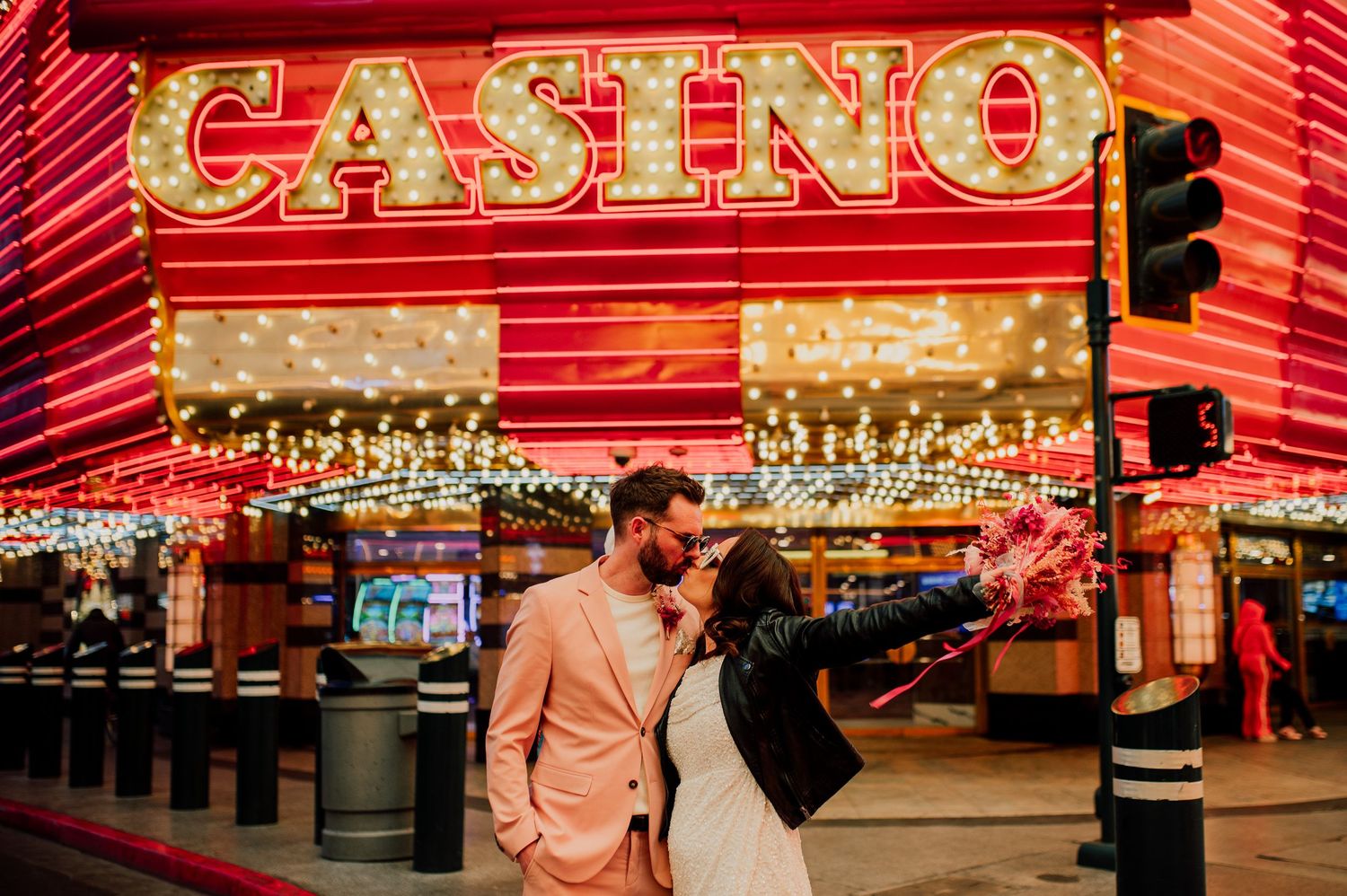 Red neon casino signs illuminate a row of gaming establishments along Fremont Street in downtown Las Vegas.
