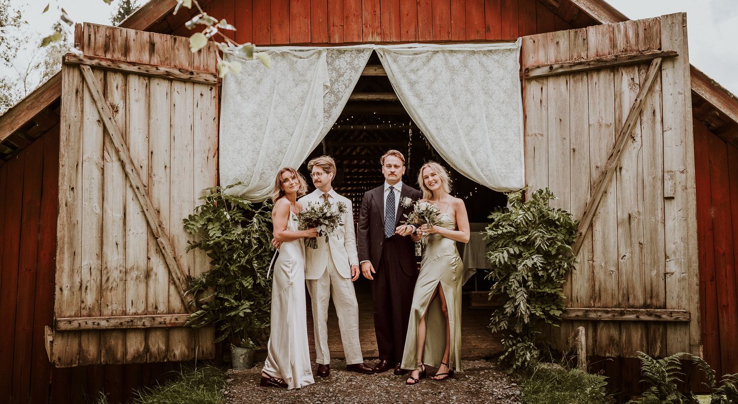 Brudpar med bestman och tärna står utanför en bröllopslada i Mullsjö. Dörren har vita spetsgardiner och det står gröna växter utanför.