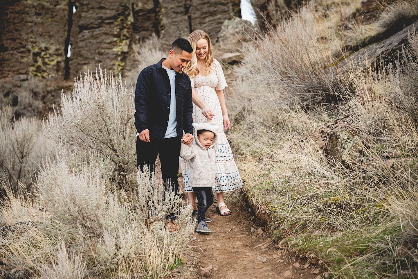 family walking down trail at frenchman coulee, holding hands
