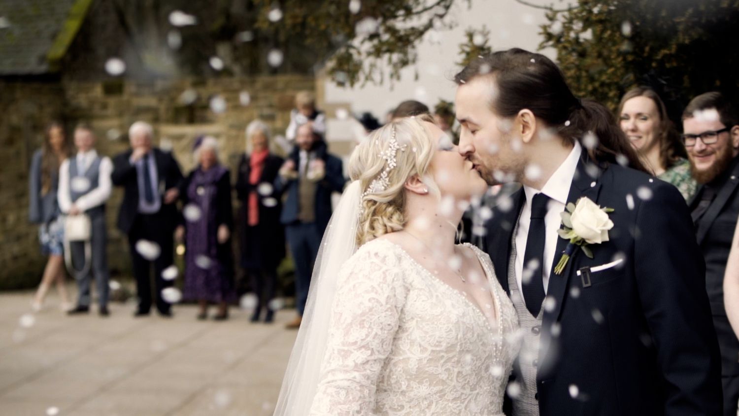 A celebratory wedding moment with confetti falling in the outdoor setting.