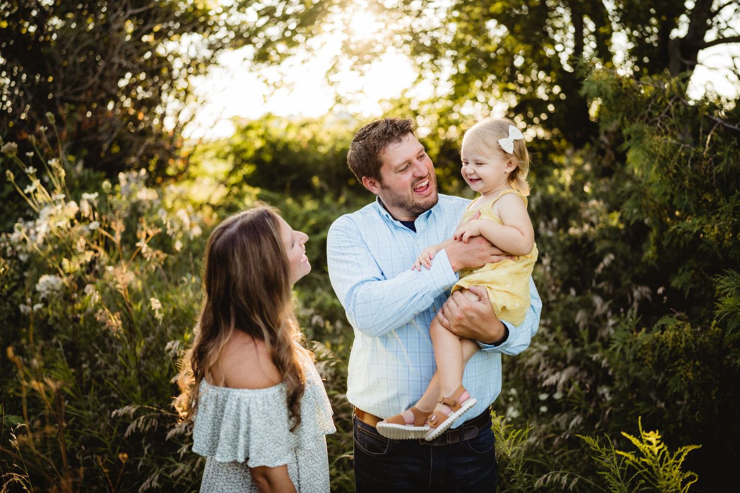 Family enjoying golden hour together in lush garden setting.