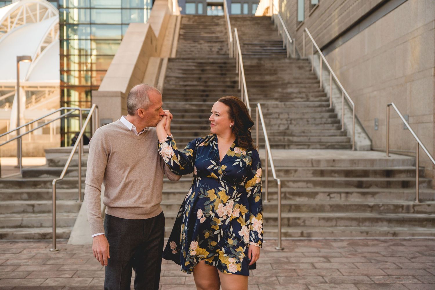 Couple sharing joyful moment on urban concrete steps.