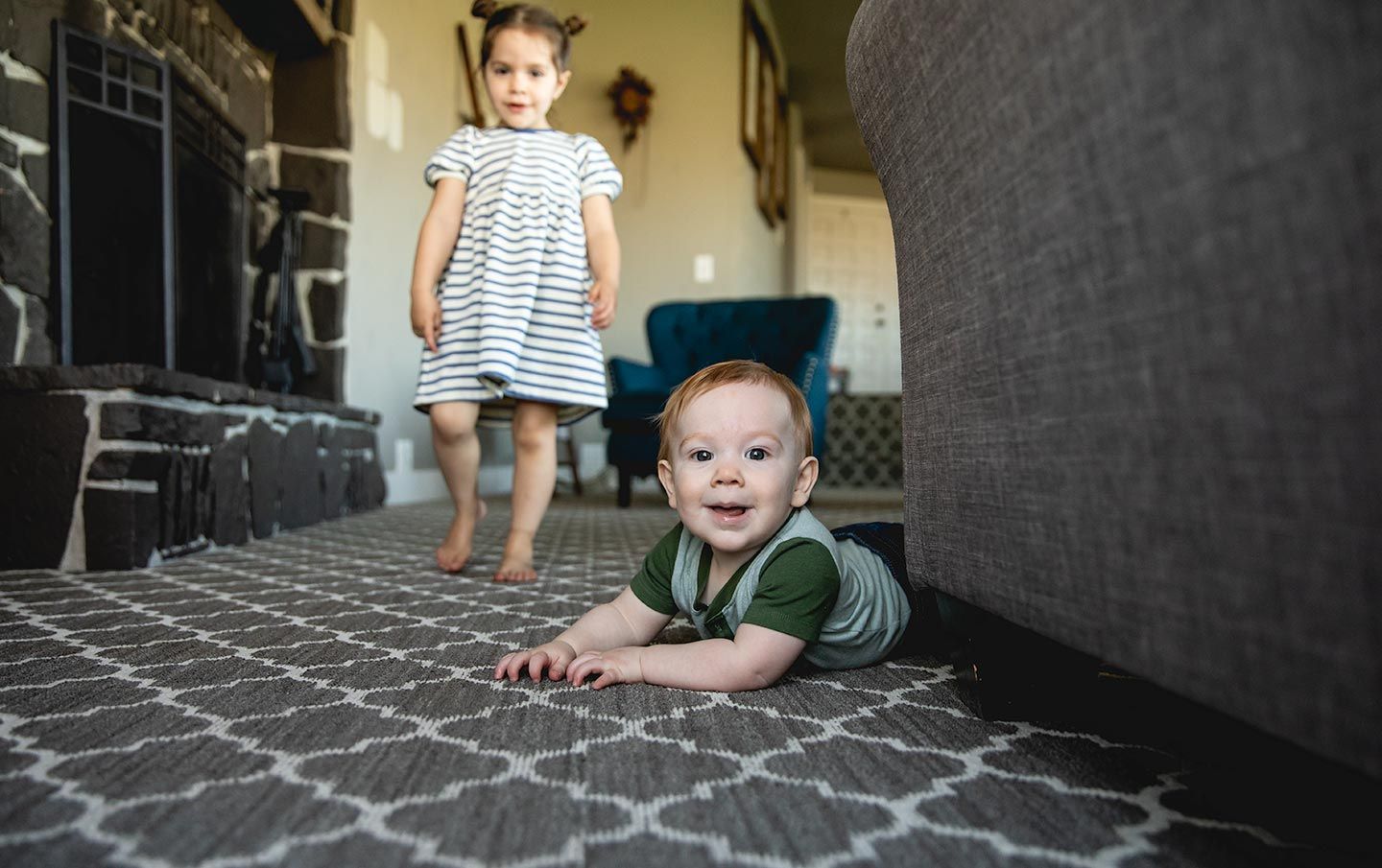 baby boy army crawling on the floor next to the couch