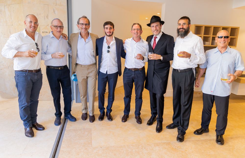 A group of formally dressed individuals stand together at a professional event.