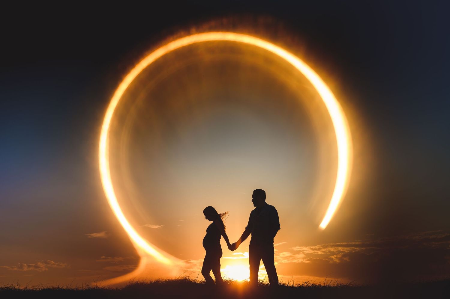 maternity couple holding hands in ring of fire
