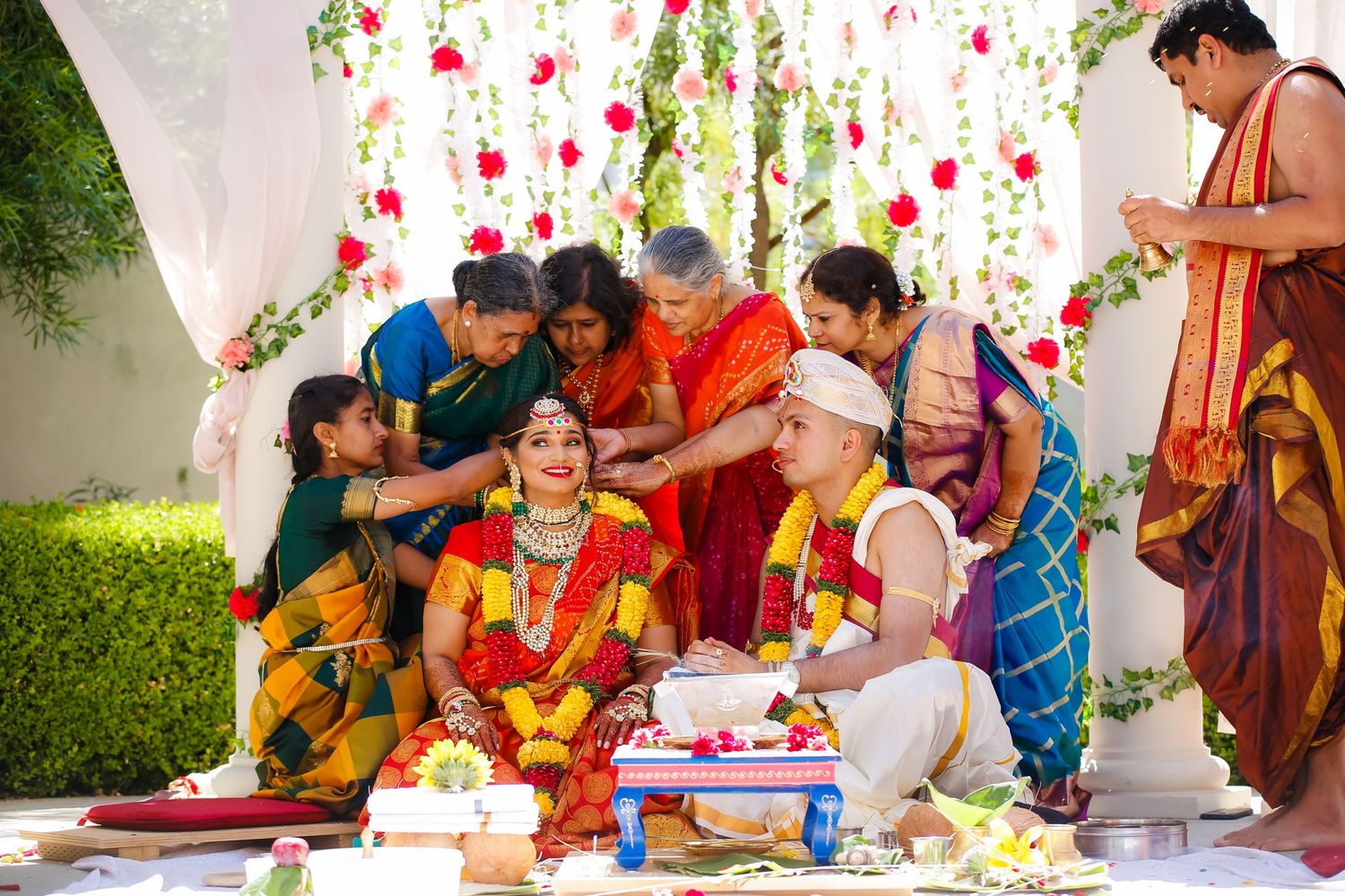 Traditional Indian wedding ceremony with colorful decorations and rituals being performed.