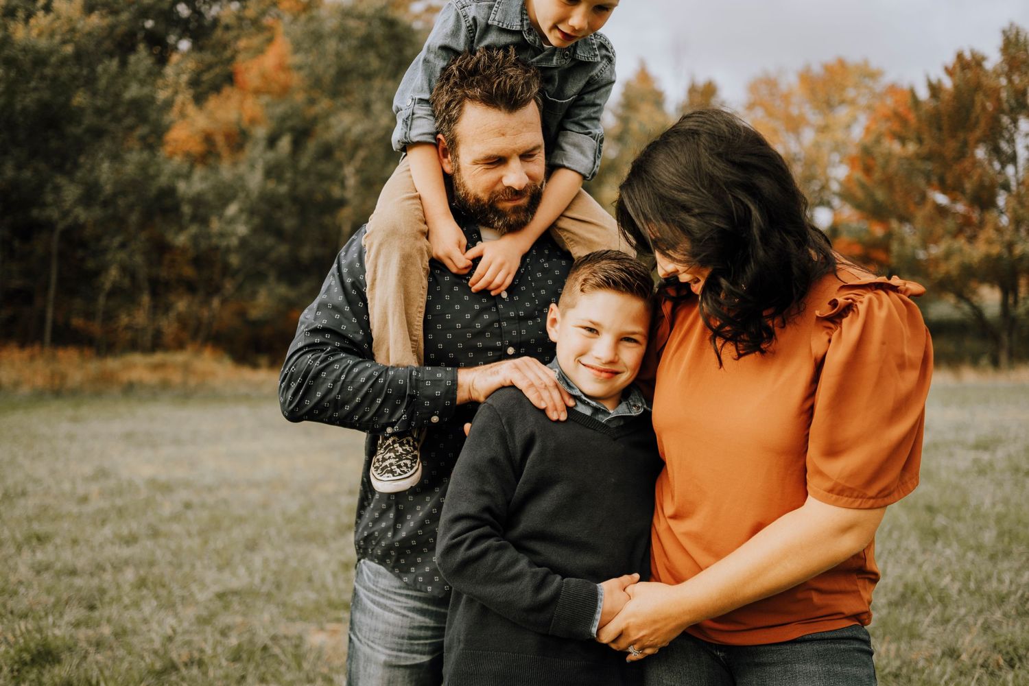 Happy family sharing playful moment together on autumn day.
