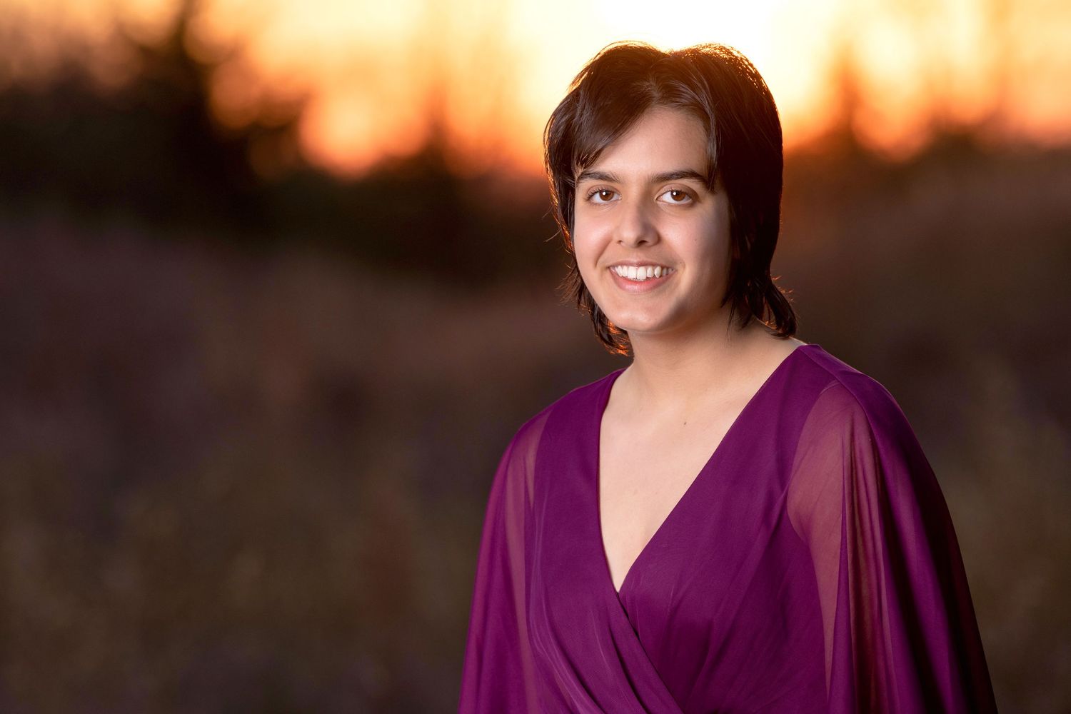 Sunset portrait in rich purple dress with warm golden lighting.
