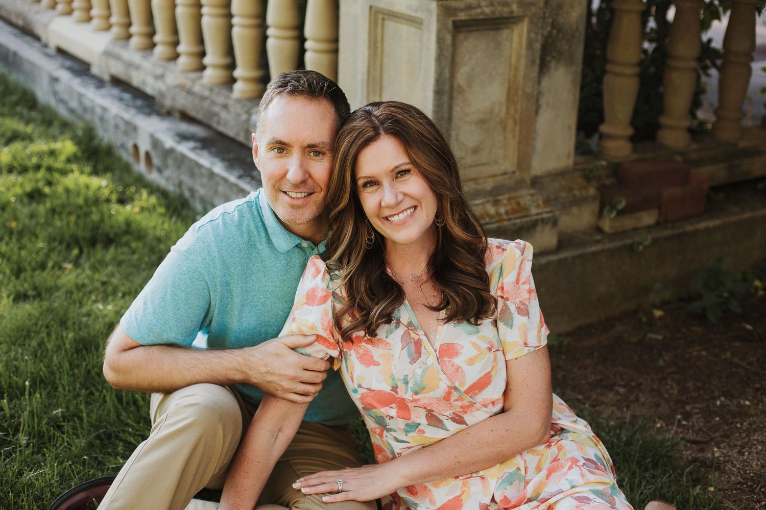 Couple sitting together on stone steps in garden setting during spring.