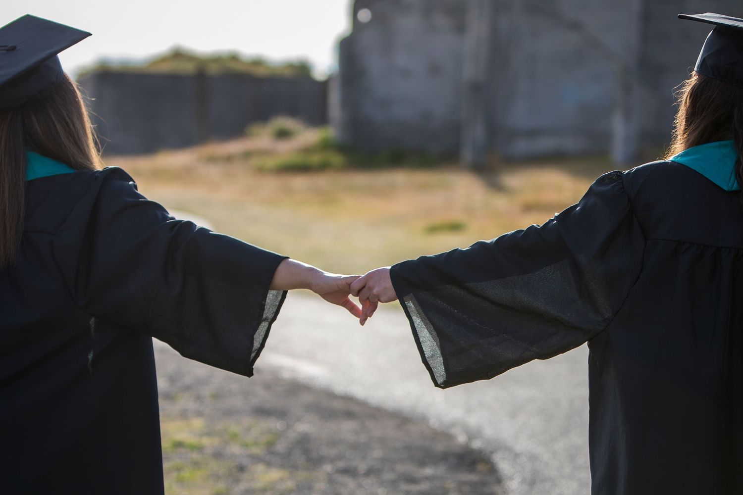 Jackie Phairow Photography cap and gown portrait of seniors holding hands