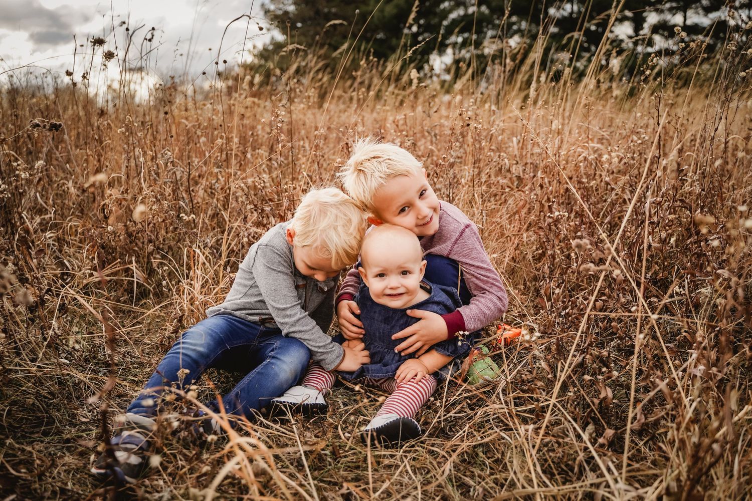 Three children hugging in a prairie