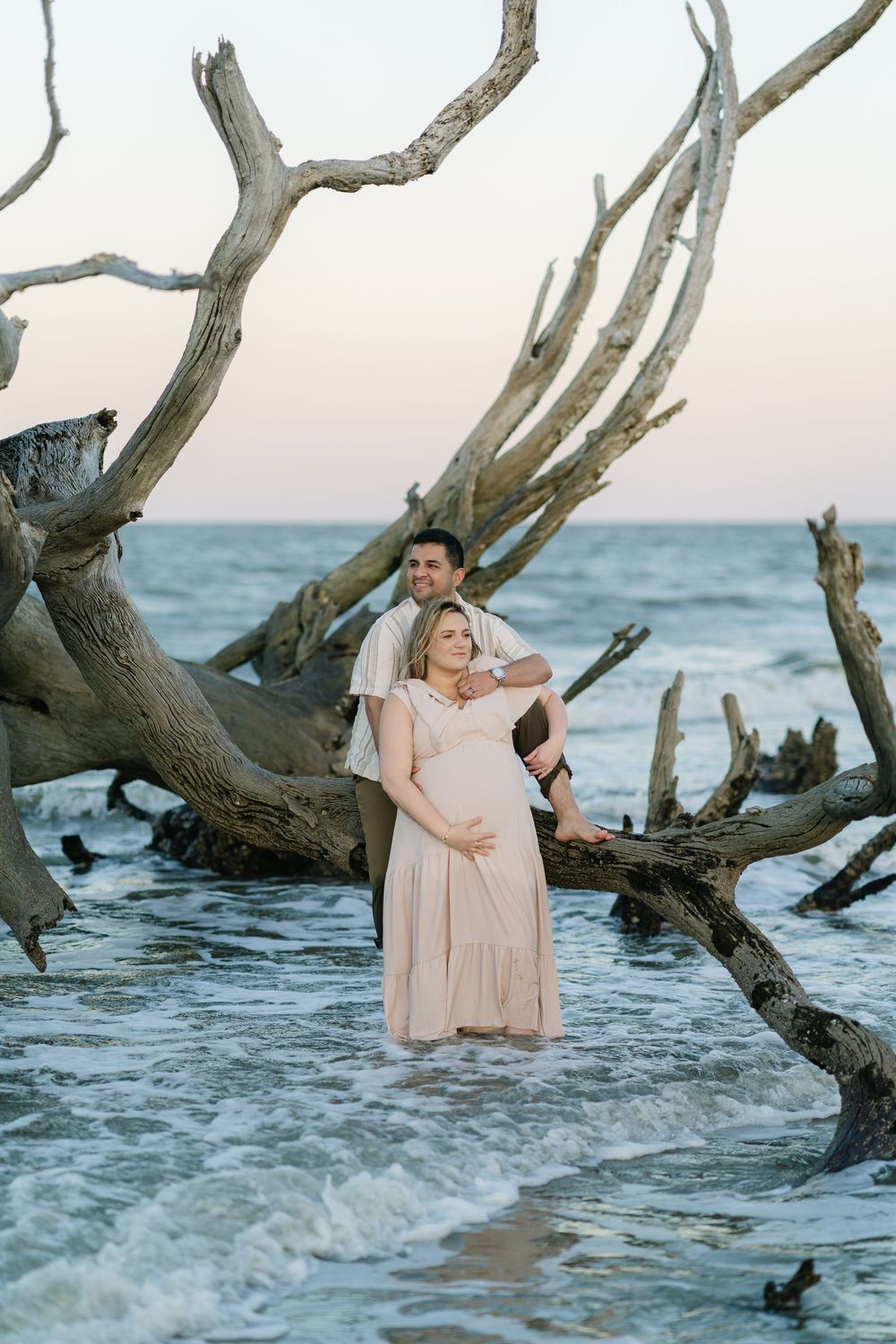 Expectant parents standing together at the ocean edge of their maternity portrait session, blog from Lindy Rebro Amelia Island Photographer