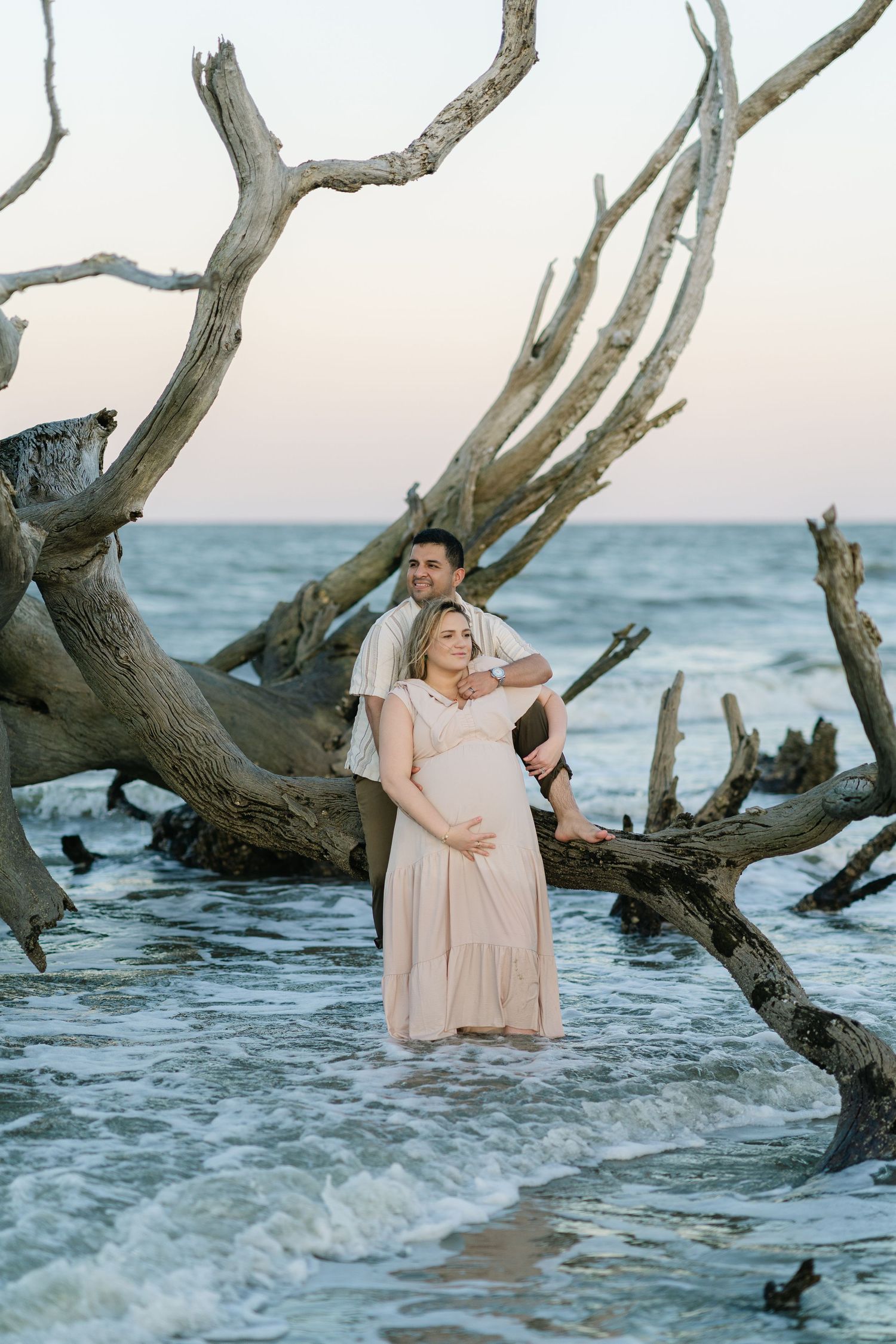 Expectant parents standing together at the ocean edge of their maternity portrait session, blog from Lindy Rebro Amelia Island Photographer
