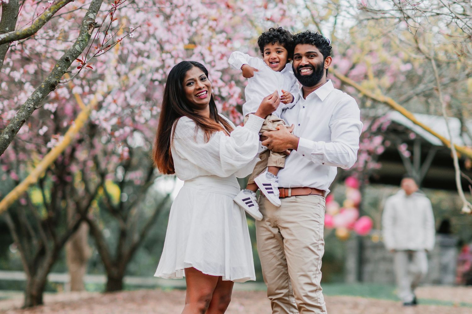 A family poses together outdoors in coordinated outfits during a lifestyle photography session.