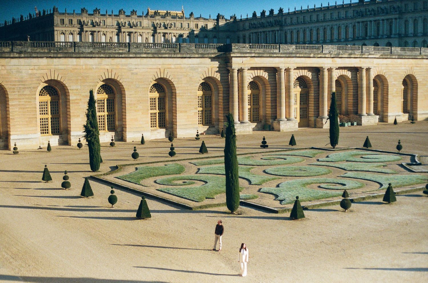 Ornate geometric garden with manicured hedges and pathways at the Palace of Versailles on film photography.