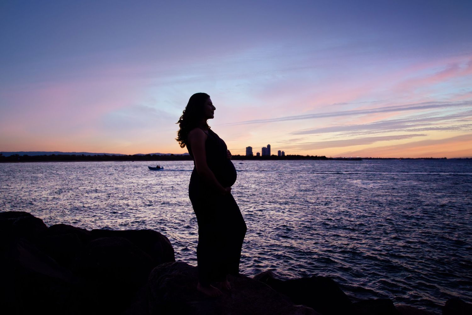 Maternity photography Palm Beach featuring an artistic silhouette against the ocean.