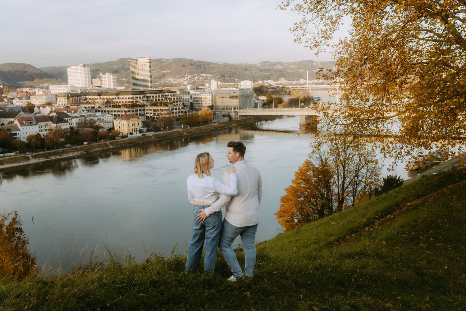 Paar steht am Schlossberg in Linz mit Blick auf Urfahr