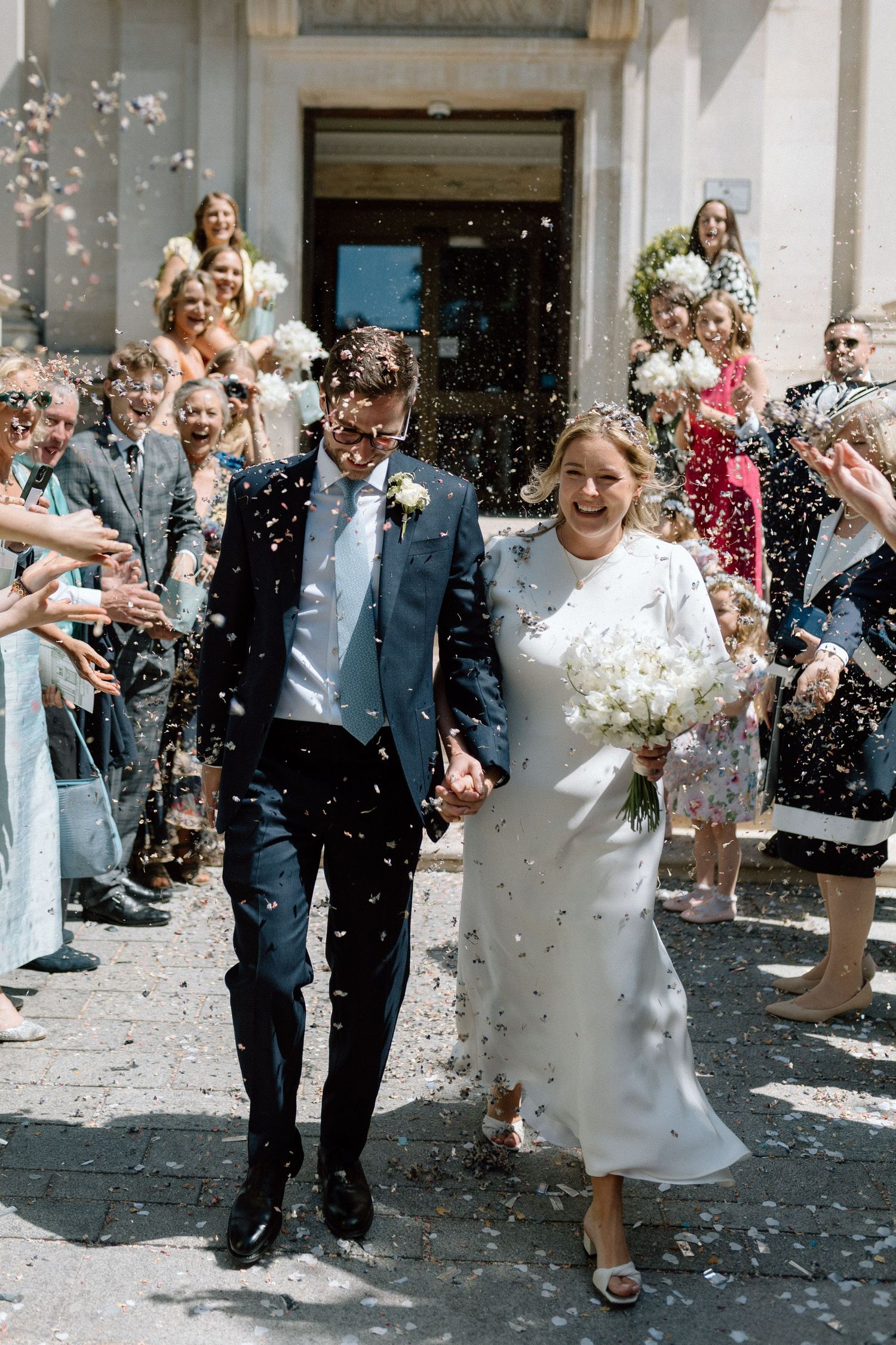 Wedding guests shower newlyweds with confetti as they joyfully exit Islington Town Hall in London after their ceremony.