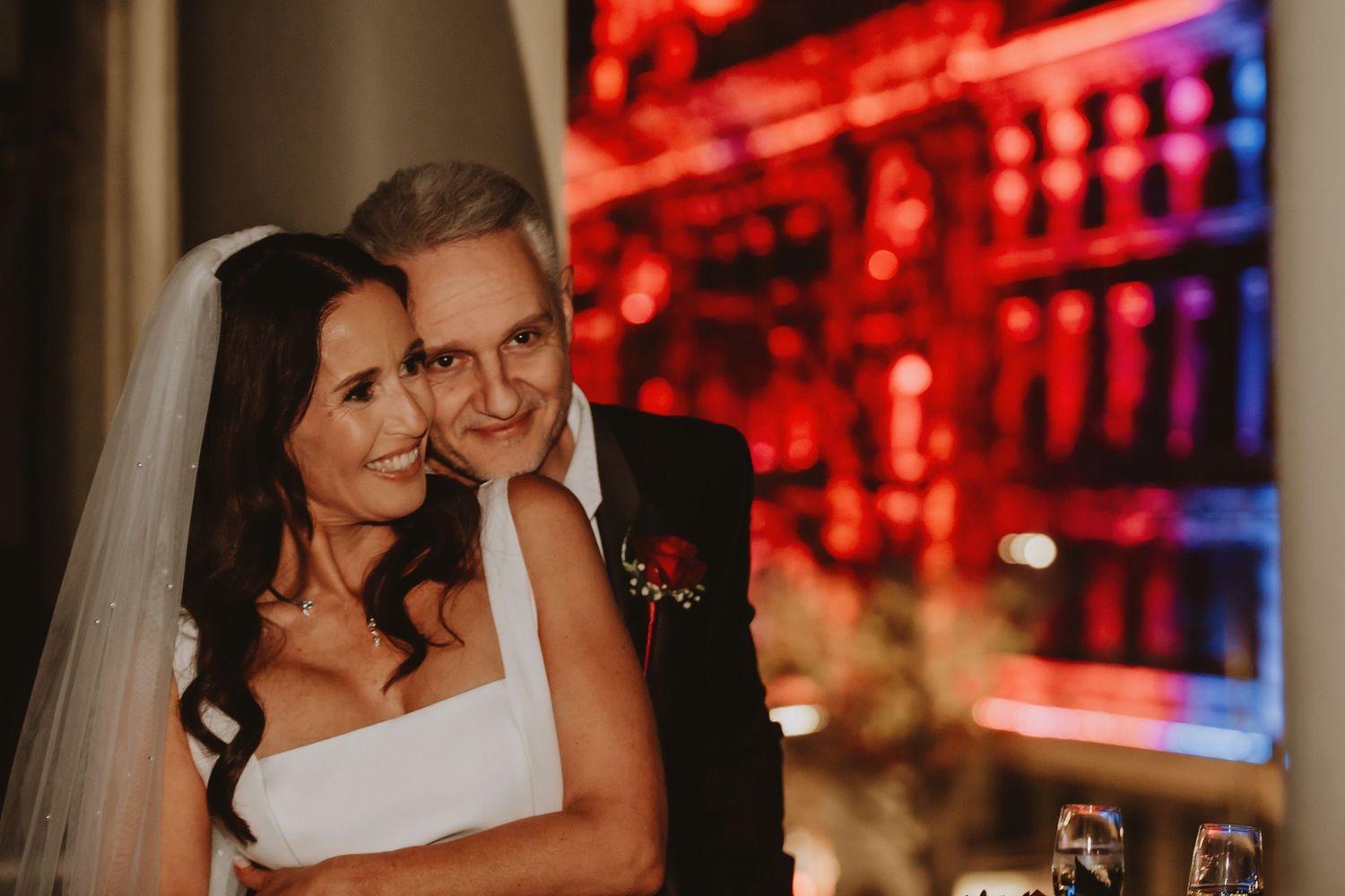 A series of wedding celebration photos showing romantic moments with red ambient lighting in the background.