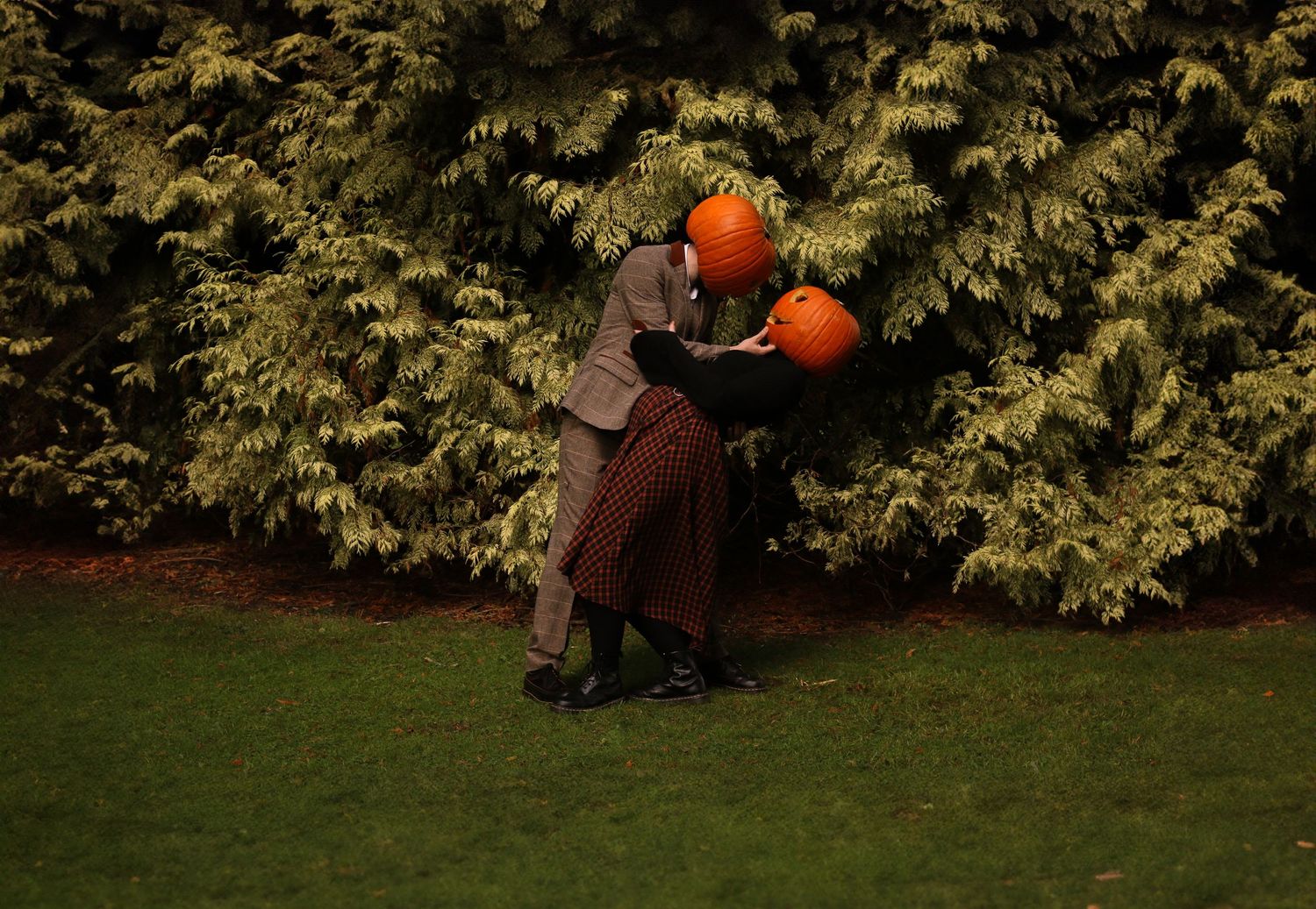 A couple stands outdoors holding carved jack-o'-lantern pumpkins in a four-part series of autumn photos.