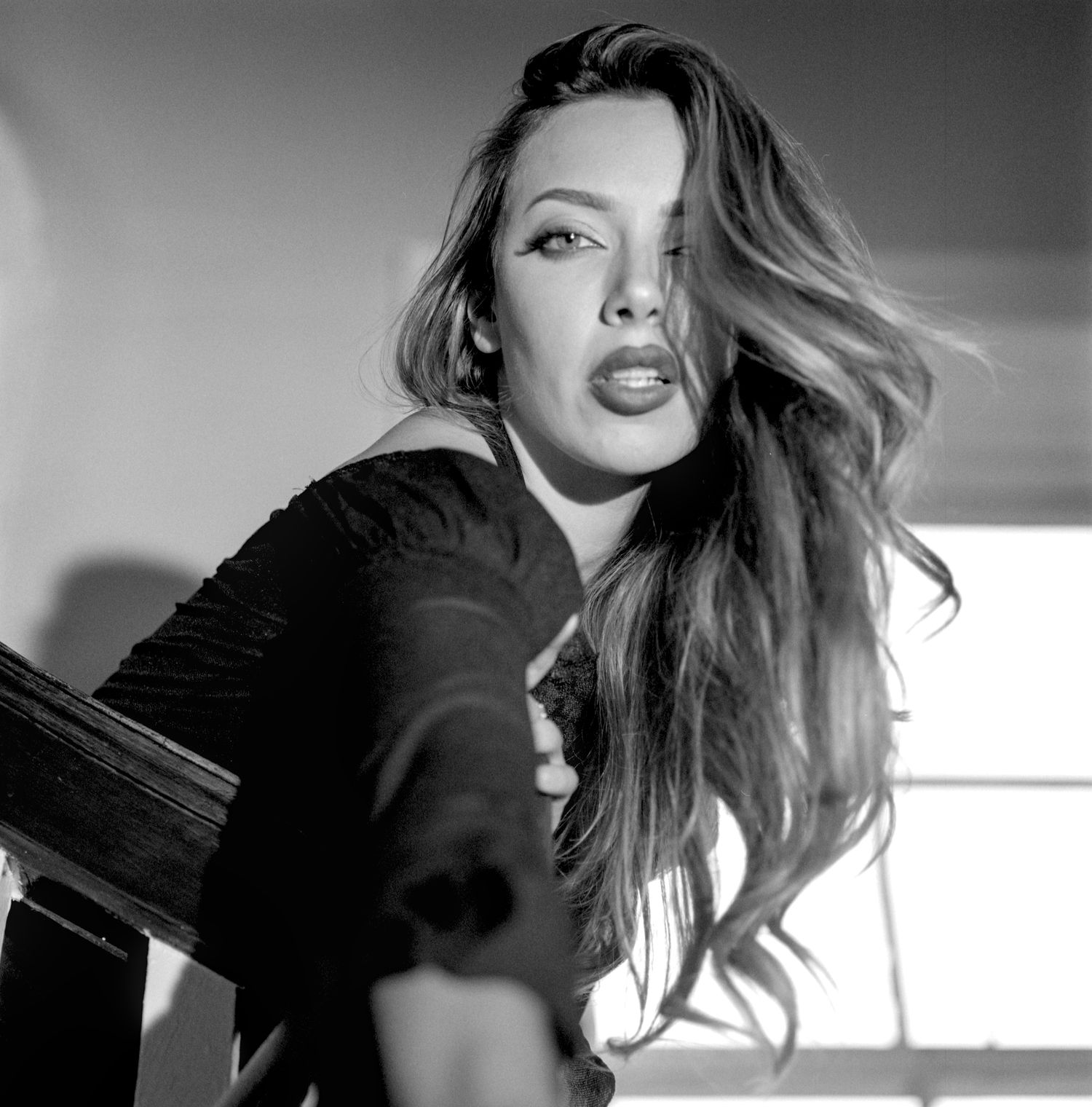 Black and white portrait series showing windswept blonde hair movement against white background in artistic style.