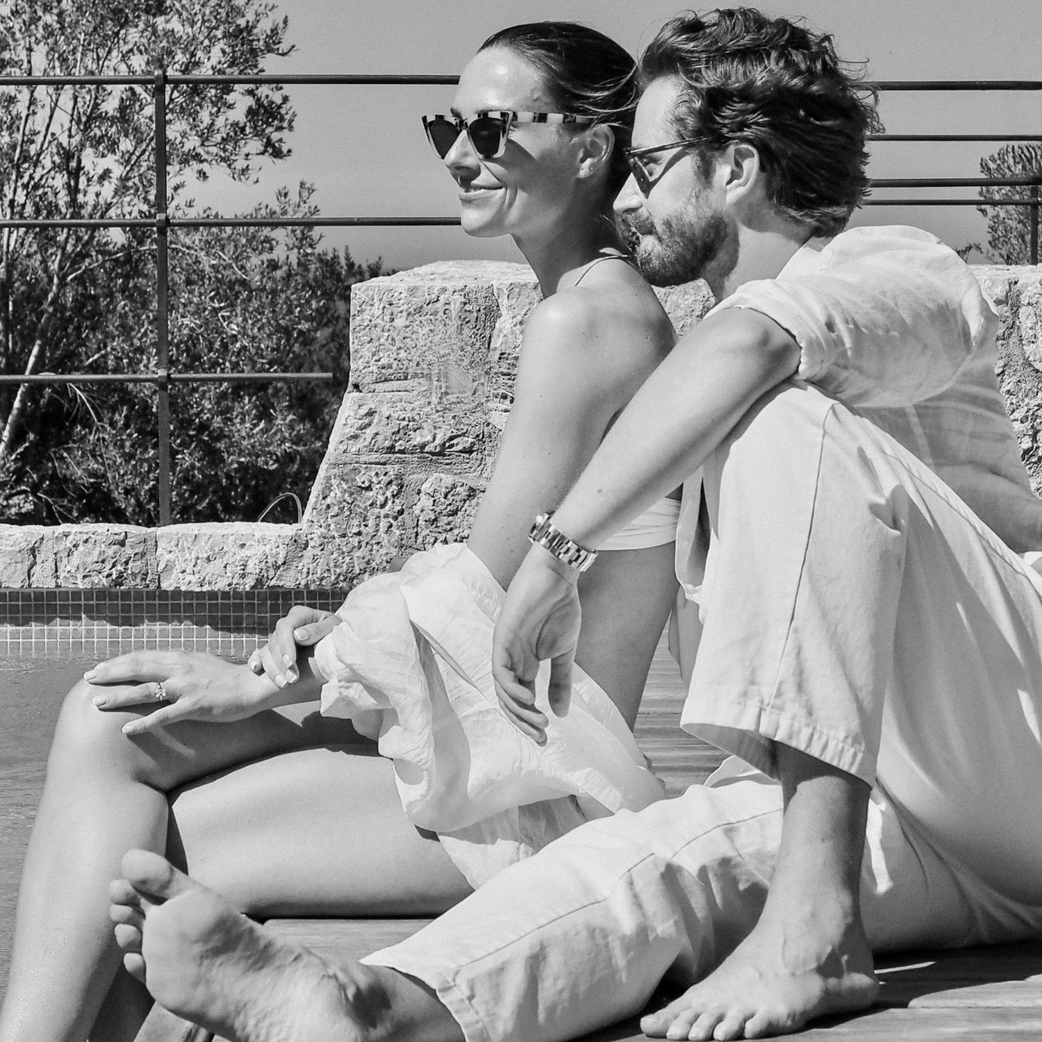 Casual summer portrait of couple relaxing outdoors in white clothing.