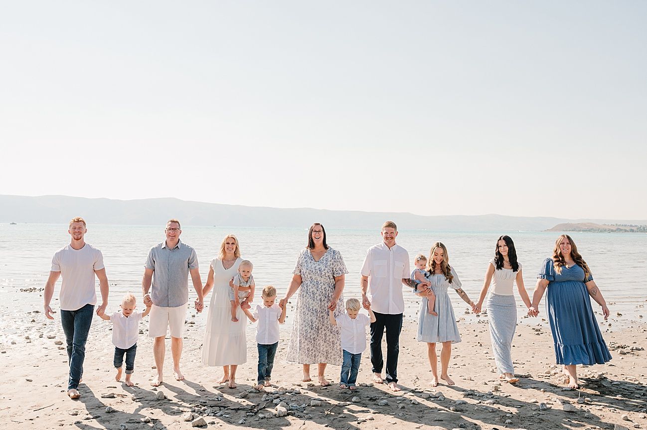 Group walking together on a sunny beach wearing coordinated white and blue outfits.