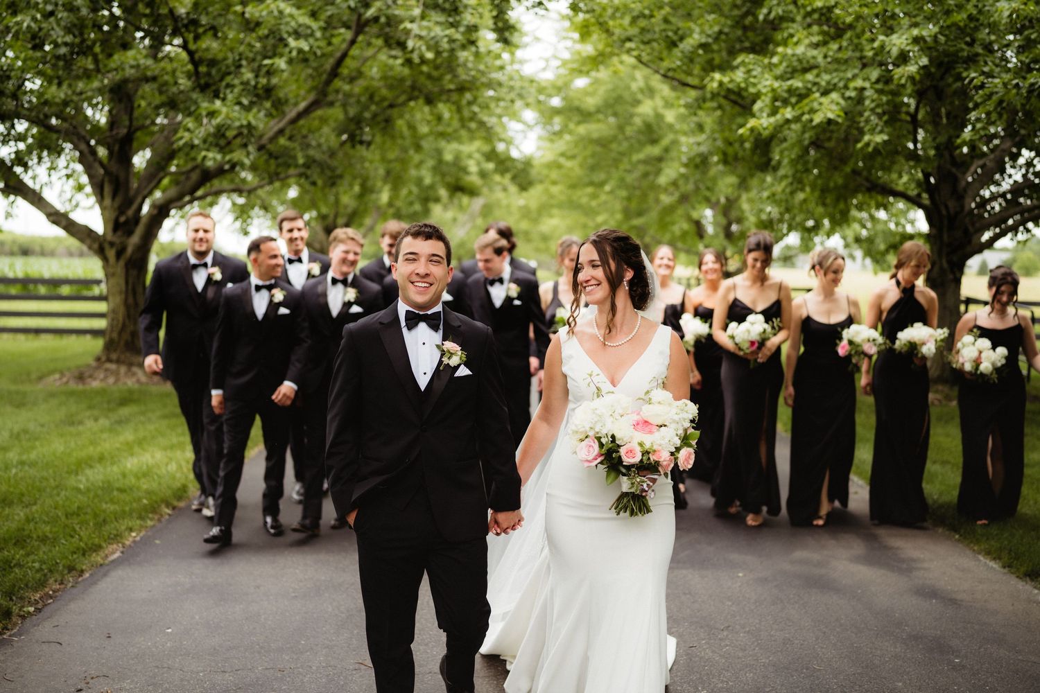 Bride and groom sharing a romantic dip kiss in front of a rustic wooden arched door with stone accents and barrel decor.