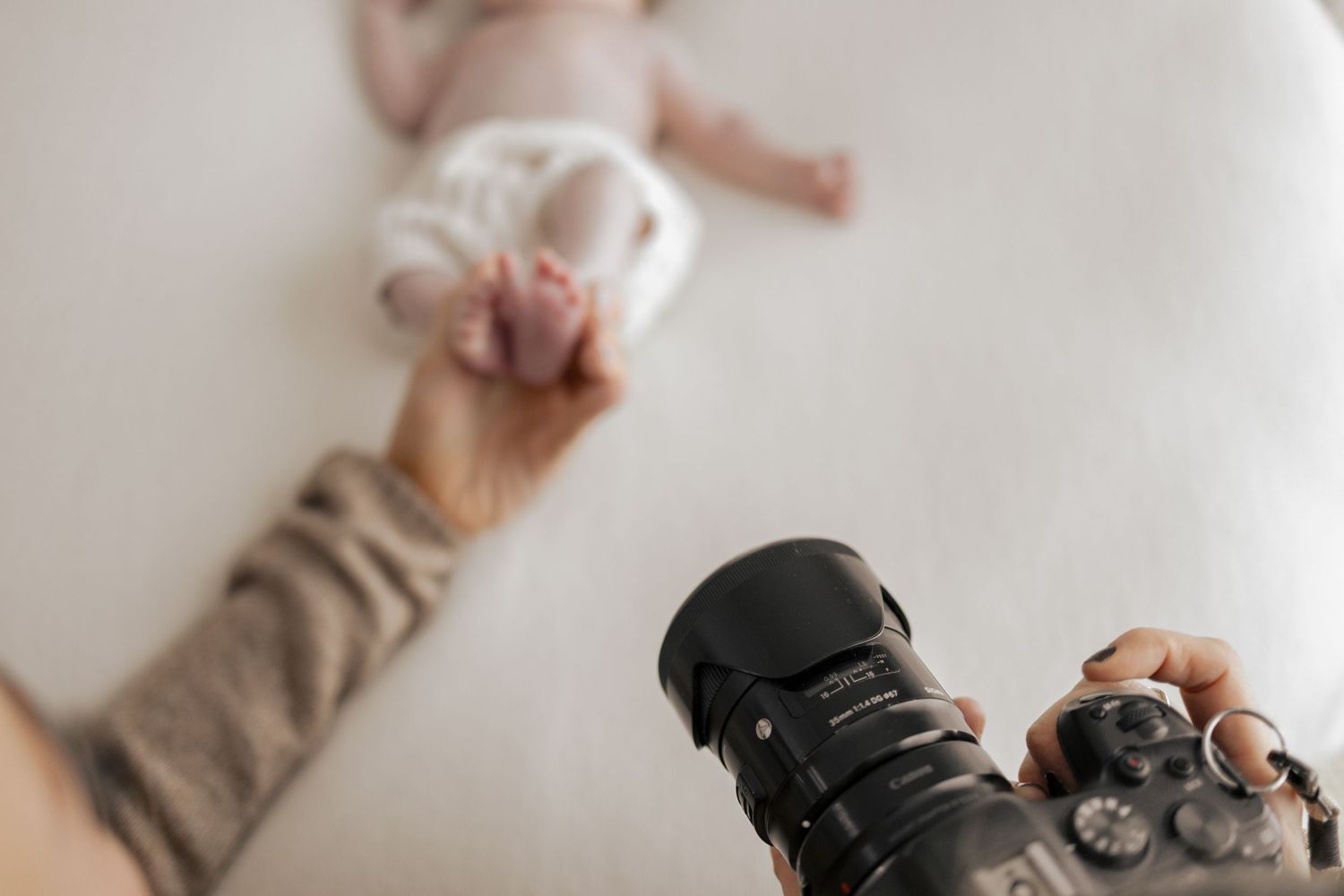 Lifestyle newborn photography session showing tender family moments on white backdrop. Photography in Buckinghamshire.