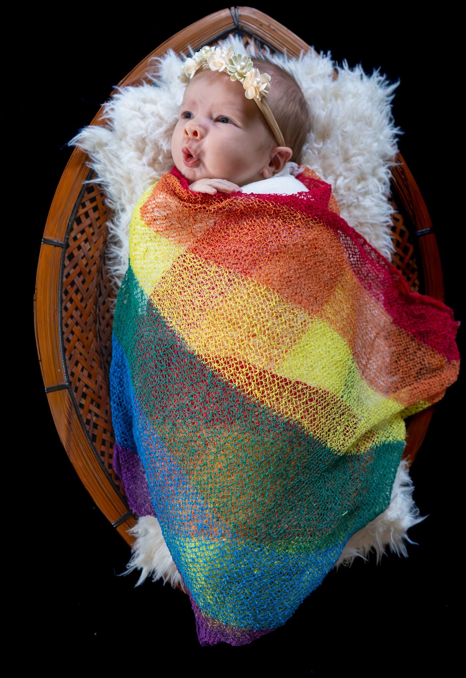 Rainbow newborn image. In home Lifestyle and prop session. Taken in Magna, Utah.
