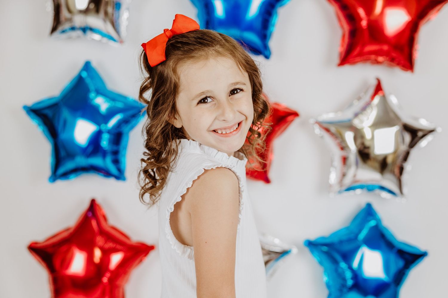 Patriotic photo shoot with star balloons in red white and blue colors.