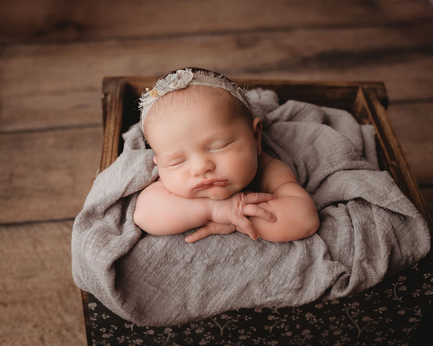 Professional photo of a newborn baby sleeping in a basket