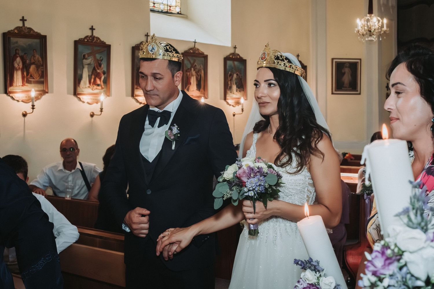 Wedding ceremony taking place inside a traditional church with religious artwork.