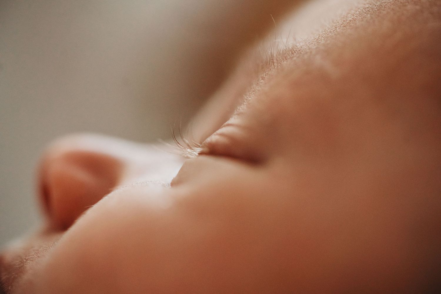 Close-up macro photo of a sleeping newborn baby's delicate nose and lips.