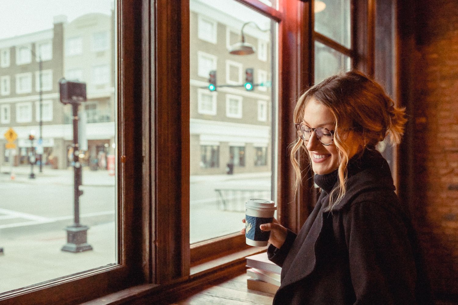 Woman laughing at Spencer's Coffee at coffee shop mini session in Bowling Green, Kentucky