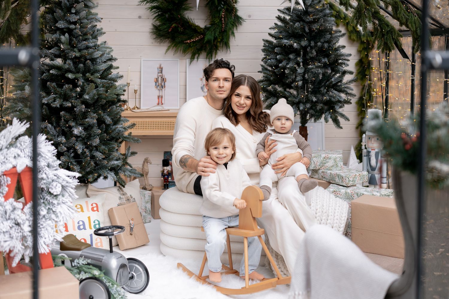 A festive Christmas scene with decorated trees and children's toys around a cozy holiday setting.