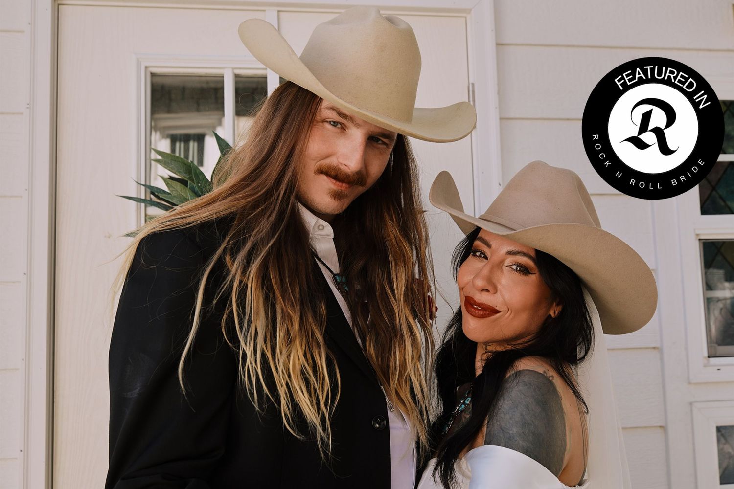 Couple in beige cowboy hats posing during editorial wedding photoshoot in Nashville.