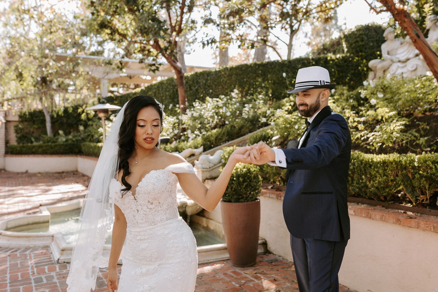 A couple shares a romantic moment in a garden setting during their wedding celebration at Rancho Bernardo Inn.