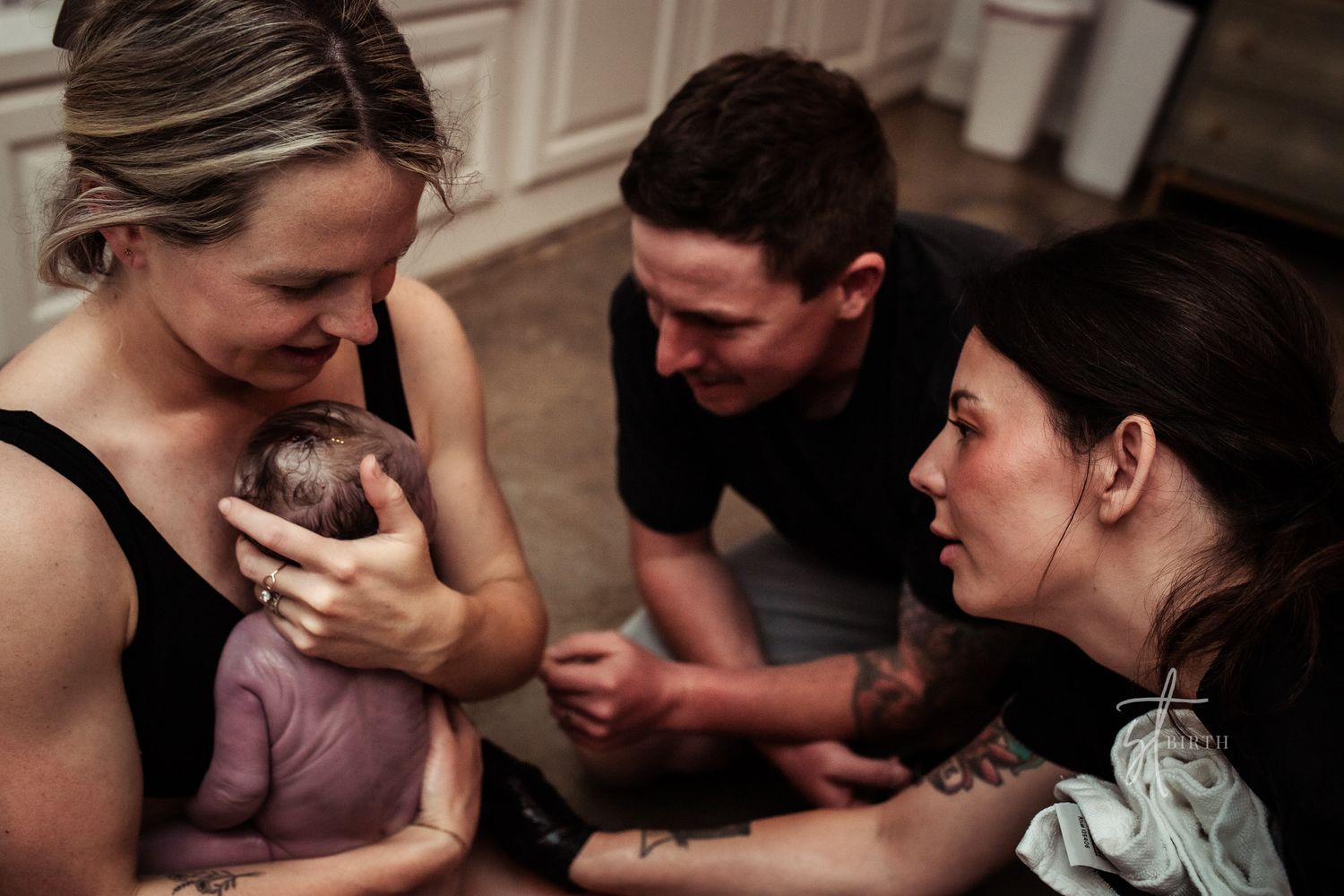 MOM-HOLDS-NEWBORN-BABY-CLOSE-TO-CHEST-SECONDS-AFTER-BIRTH-ON-HAND-AND-KNEES-IN-THE-FLOOR-WITH-GENTLE-SUPPORT-OF-MIDWIFE