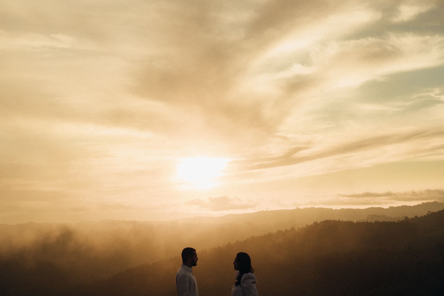 Casal se olha com pôr do Sol ao fundo em Campos do Jordão © Clara e Matheus Fotógrafos de Casamentos