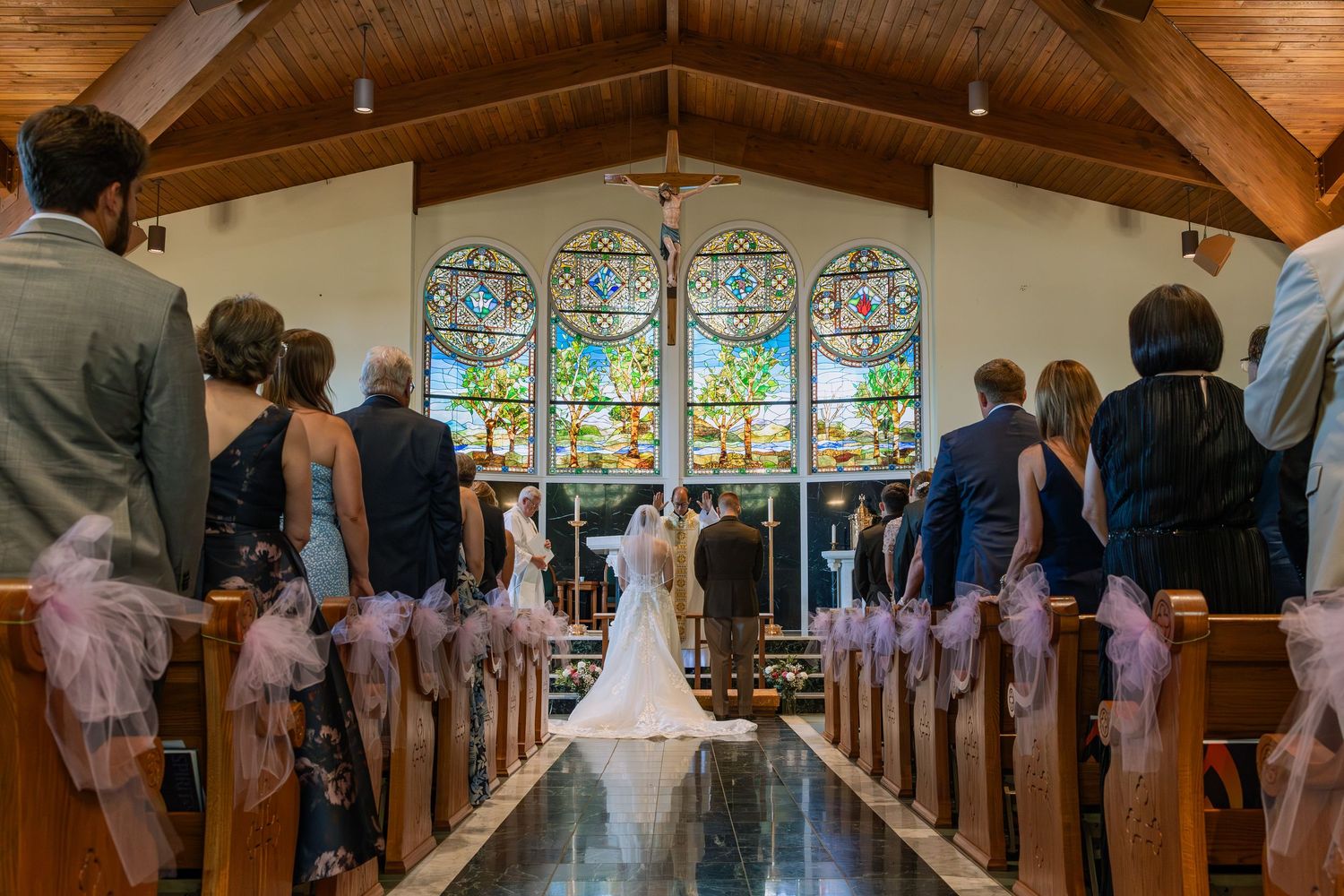 Wedding ceremony exit with guests celebrating on wooden boardwalk during autumn.