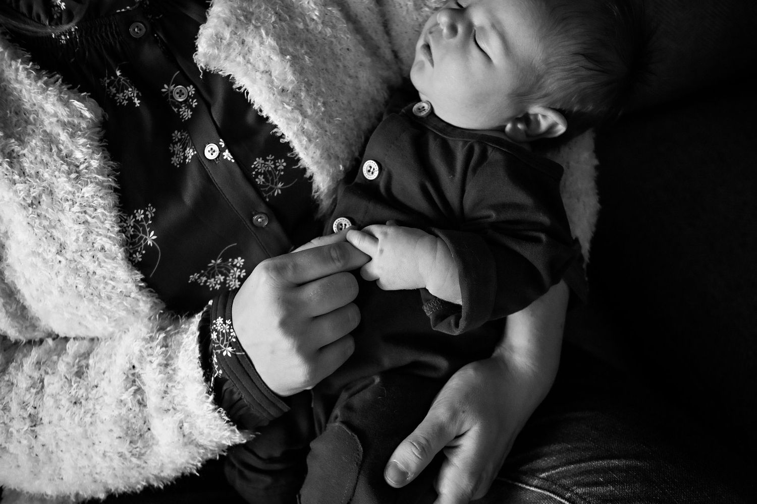 Black and white photo series showing close-up shots of a baby's hands and feet against a soft textured background.