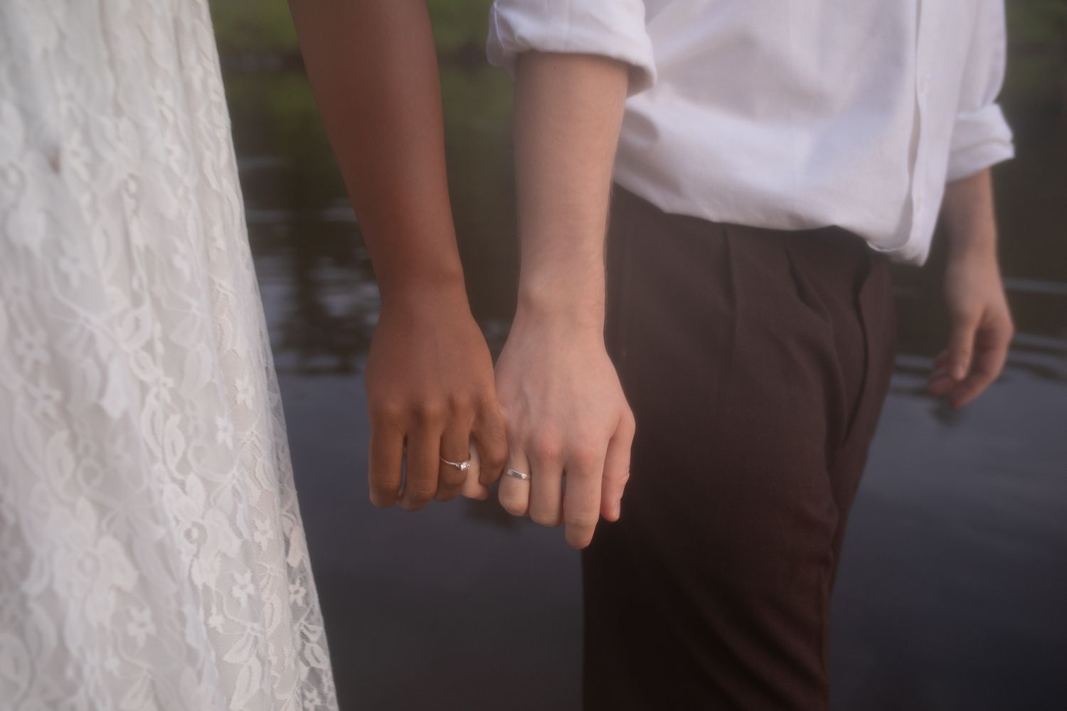 Two hands held by crossed pinkies, wedding rings showing—a couple connecting in an small intimate Mercer County Lake elopement in New Jersey
