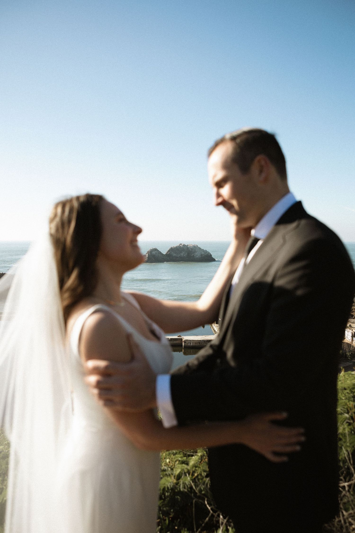 A couple standing together overlooking a scenic ocean view with rocky islands in the distance in San Francisco.