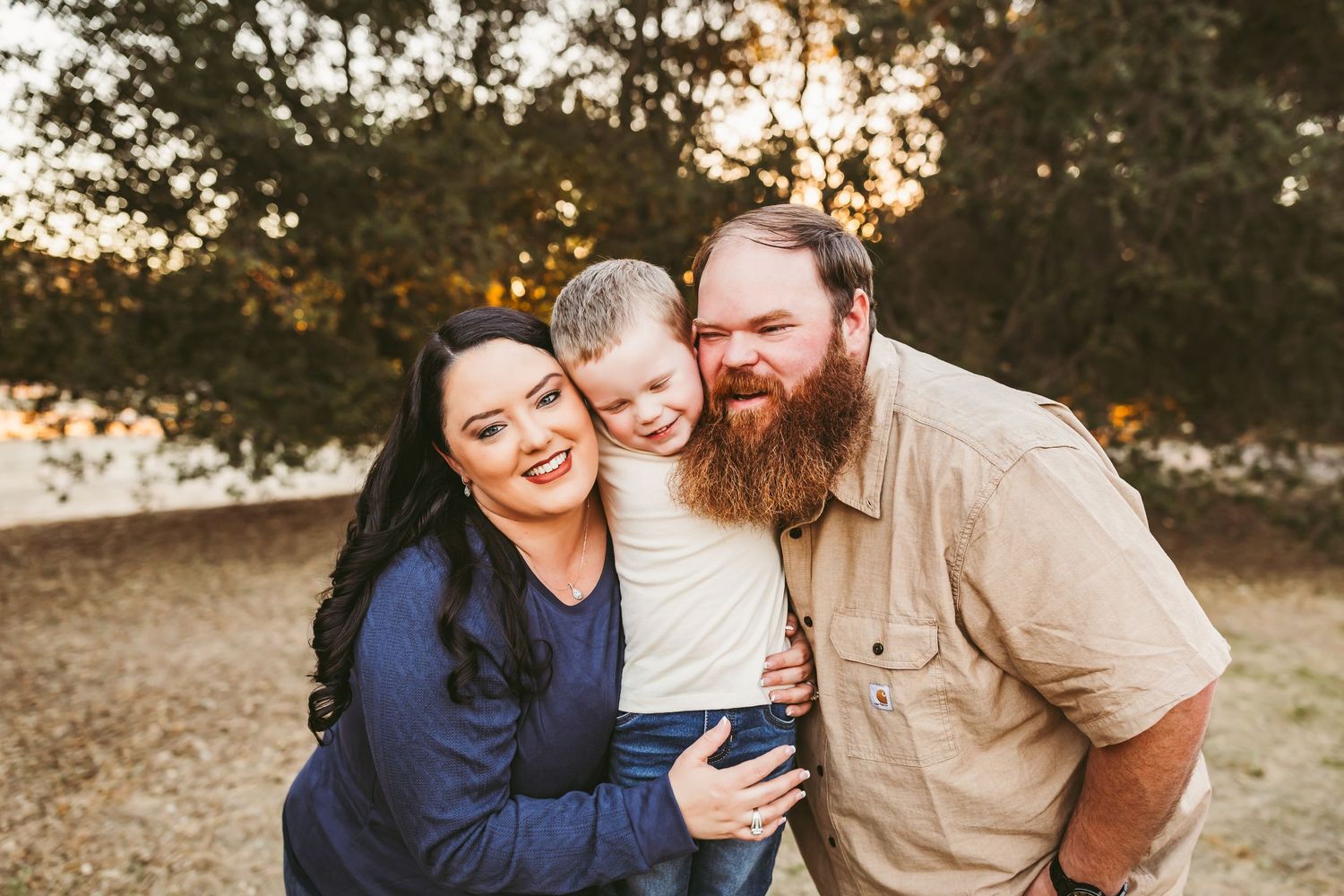 A couple shares joyful moments together outdoors during golden hour sunset in a natural setting.