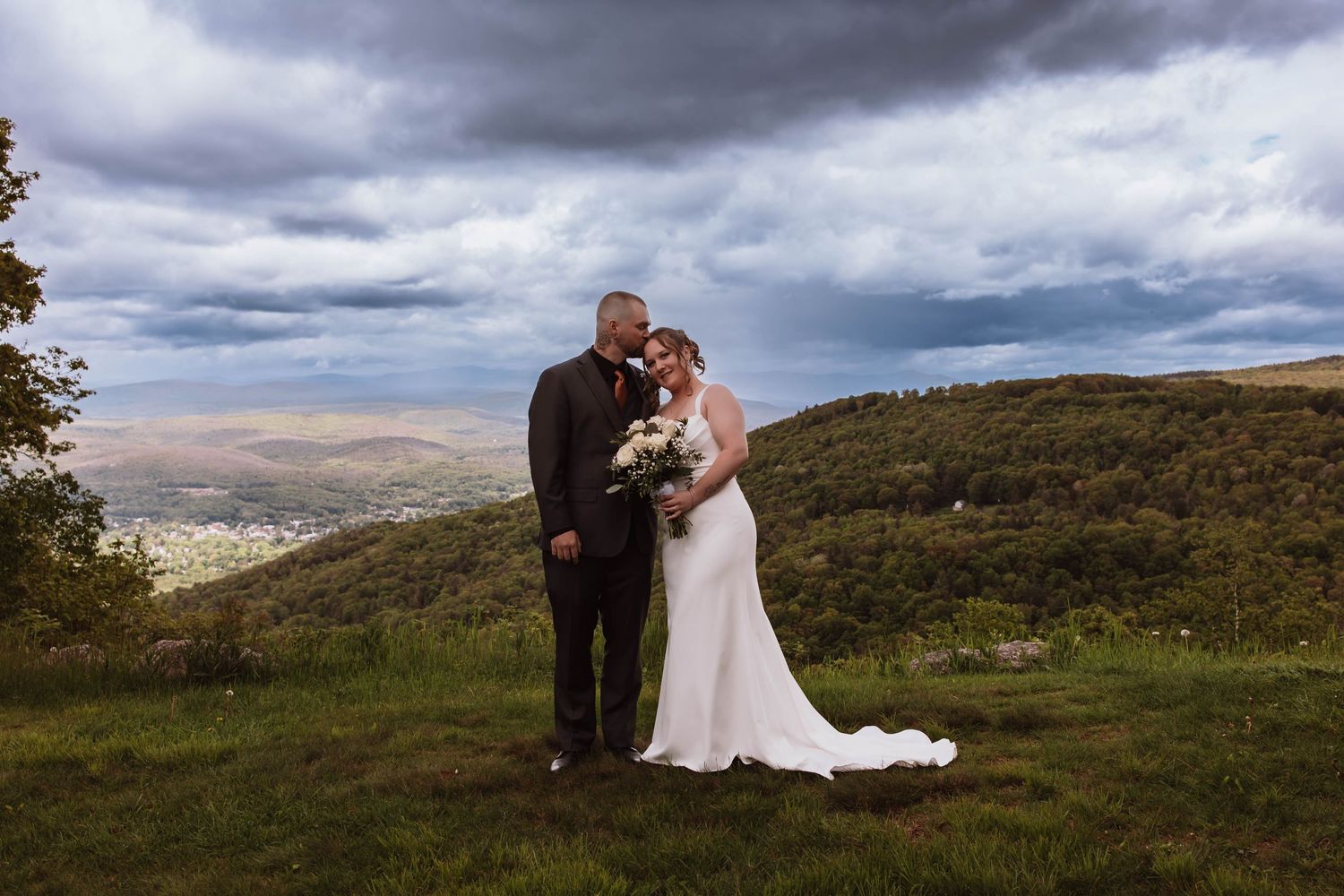 Bride and groom standing together for portraits in front of minnewaska mountains at cragsmoor stone church HVNY