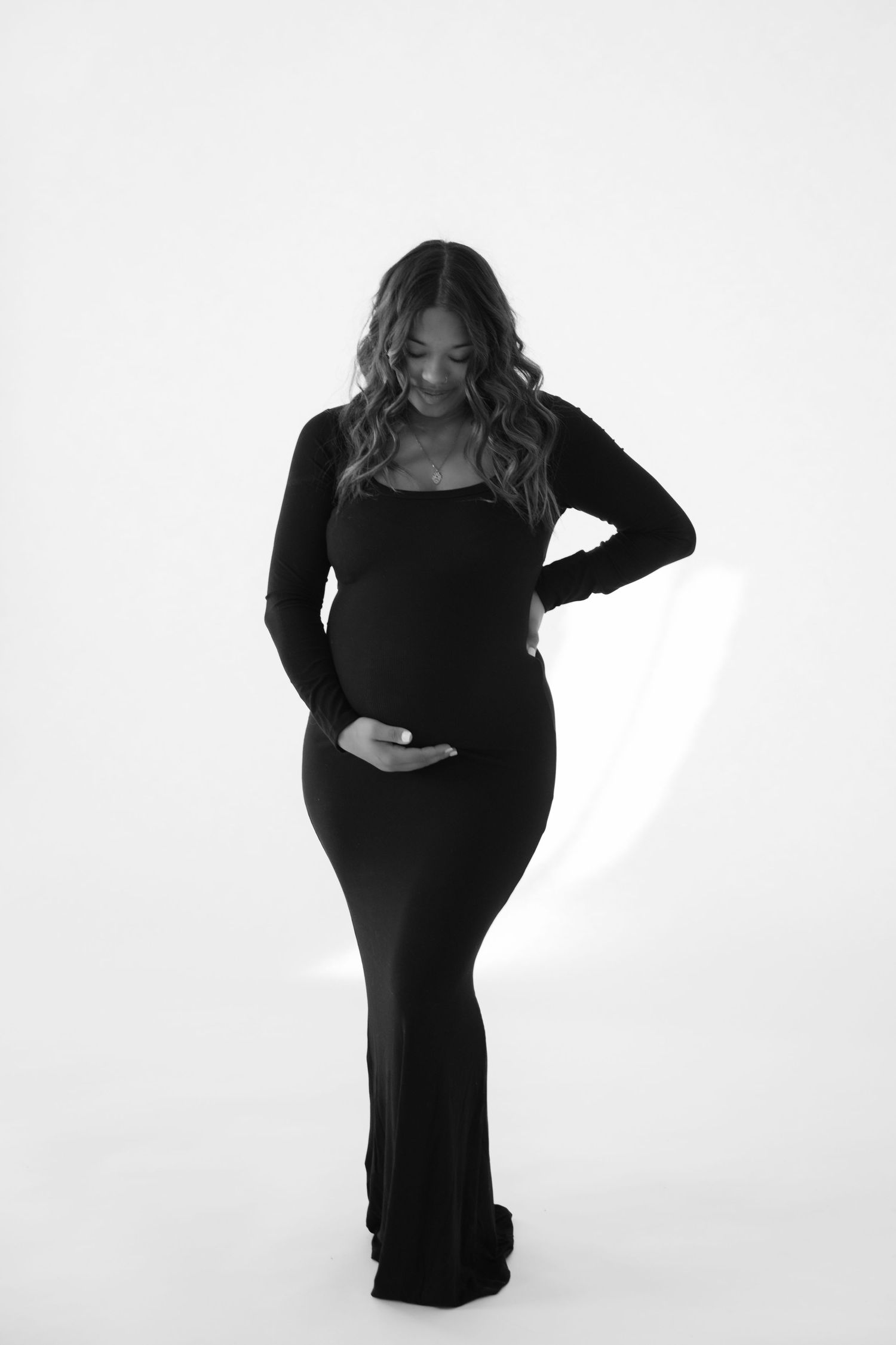 pregnant mom holding her bump during in studio maternity session in stillwater mn