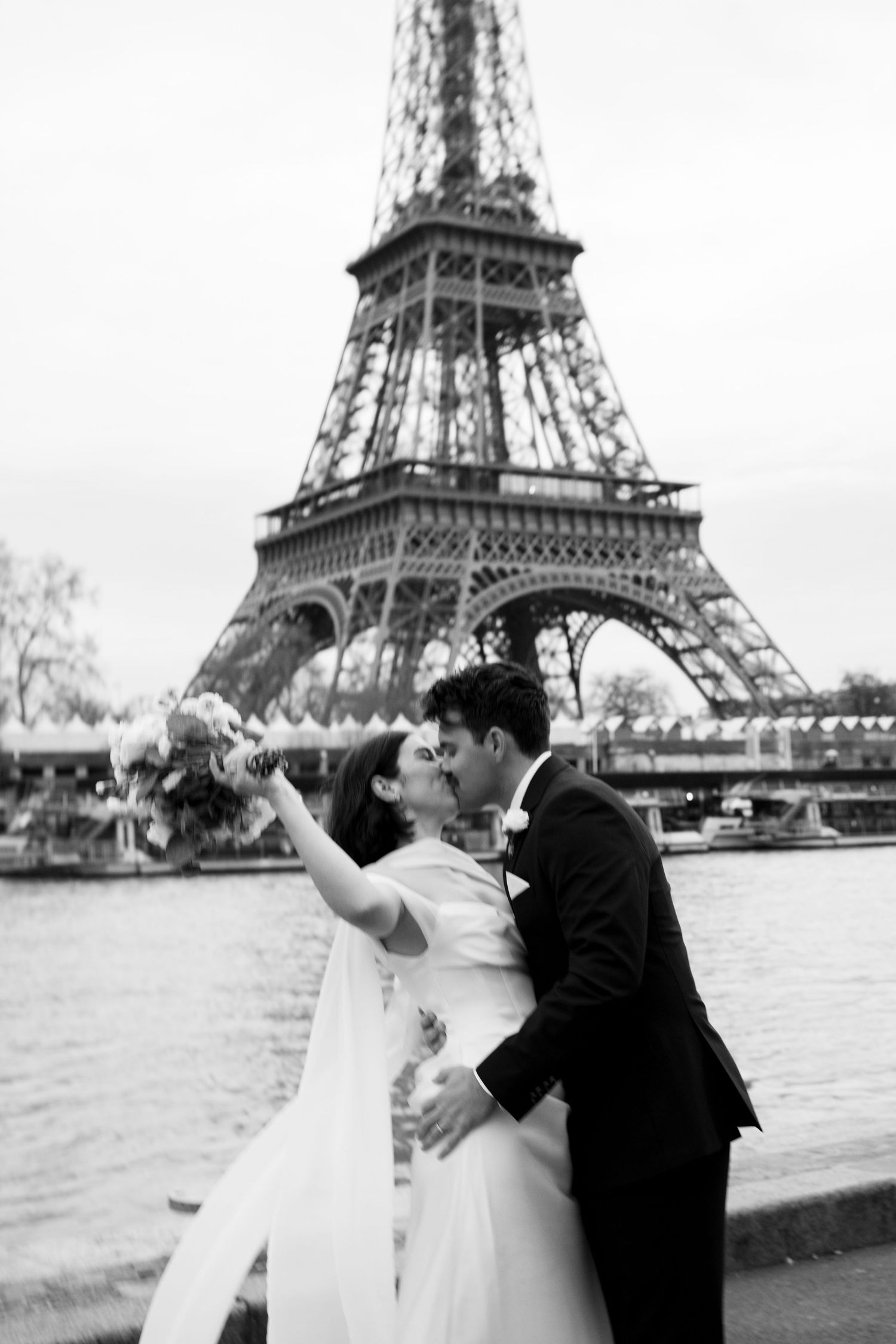 Celebratory wedding toast with champagne by the Eiffel Tower in warm sunset light.