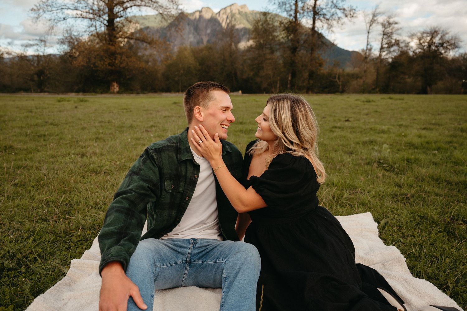 A relaxed outdoor photo session in a field with mountain views.