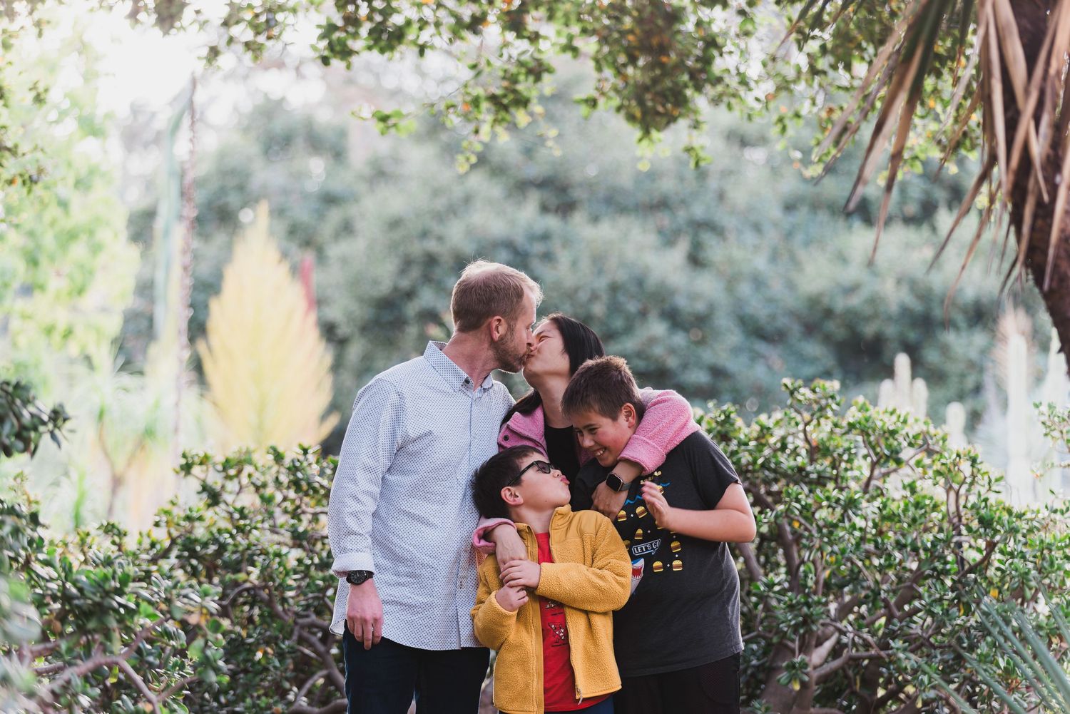 An intimate family moment captured in a garden setting with natural lighting.